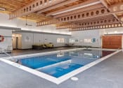 Thumbnail 23 of 27 - a large indoor swimming pool with a wooden ceiling