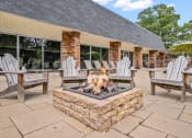 Thumbnail 16 of 27 - a patio with a firepit and chairs outside of a building