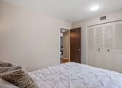Thumbnail 10 of 27 - a bedroom with a large bed and a door to a bathroom