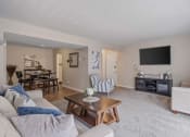 Thumbnail 2 of 27 - a living room with a couch and a coffee table in front of a tv