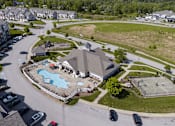 Thumbnail 28 of 29 - A large community clubhouse with a pool in front of it.