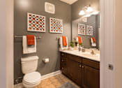 Thumbnail 17 of 29 - A bathroom with a toilet, sink, and towel racks.