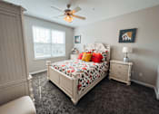 Thumbnail 16 of 29 - A bedroom with a large bed and a ceiling fan.