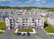 Thumbnail 29 of 29 - A large apartment complex with a parking lot in front.