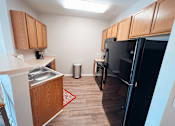 Thumbnail 11 of 29 - A kitchen with wooden cabinets and a black appliances.