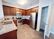Thumbnail 4 of 29 - A kitchen with wooden cabinets and a refrigerator.
