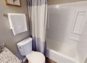 Thumbnail 8 of 20 - a bathroom with a toilet and a bath tub