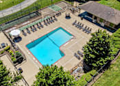 Thumbnail 19 of 35 - A large outdoor swimming pool surrounded by a fence and lounge chairs.