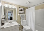 Thumbnail 9 of 35 - A bathroom with a toilet, sink, and shower.
