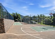 Thumbnail 26 of 35 - A basketball court surrounded by a black fence.