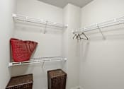 Thumbnail 8 of 35 - A red bag hangs on a white shelf in a white closet.