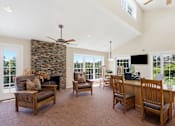 Thumbnail 12 of 35 - A living room with a stone fireplace and a television.