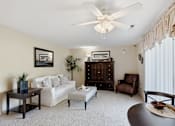 Thumbnail 1 of 35 - A living room with a white couch, a coffee table, and a ceiling fan.