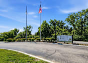Thumbnail 31 of 35 - A sign for Village Royale is displayed in front of a grassy area.