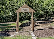 Thumbnail 21 of 35 - A wooden Nature Trail sign is in front of a wooded area.