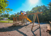 Thumbnail 14 of 15 - Playground with swing at Village Royale Apartments