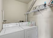 Thumbnail 5 of 35 - A white washing machine and dryer in a small laundry room.