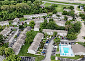Thumbnail 34 of 35 - A bird's eye view of a residential area with houses, cars, and a swimming pool.