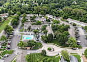 Thumbnail 32 of 35 - An aerial view of a neighborhood with houses, a pool, and a parking lot.