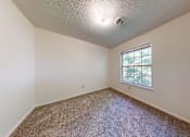 Thumbnail 19 of 35 - A room with a window and carpeted floor.