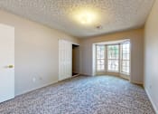 Thumbnail 15 of 35 - A room with a carpeted floor and a door leading to another room.