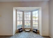 Thumbnail 6 of 35 - A room with a carpet floor and a window with a view of the outside.