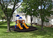 Thumbnail 20 of 35 - A playground with a blue and yellow slide in the middle of a grassy area.