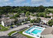 Thumbnail 31 of 35 - A swimming pool surrounded by houses and trees.
