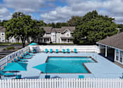 Thumbnail 21 of 35 - A pool surrounded by a white picket fence with blue umbrellas.