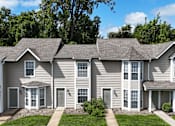 Thumbnail 26 of 35 - A row of houses with grey siding and white trim.
