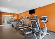 Thumbnail 14 of 23 - a gym with cardio equipment and weights at apartment complex