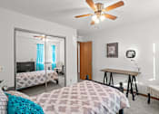 Thumbnail 7 of 23 - a bedroom with a bed and a ceiling fan