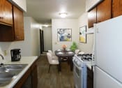Thumbnail 3 of 15 - Kitchen area with refrigerator, oven, and double sink at west broadway apartments