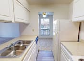 Thumbnail 6 of 27 - A kitchen with white cabinets and a stainless steel sink.