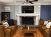 Thumbnail 11 of 33 - A clubhouse with a fireplace and a television.