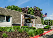 Thumbnail 20 of 26 - a brick building with an american flag in front of it