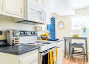 Thumbnail 5 of 26 - a kitchen with microwave and a stove top oven