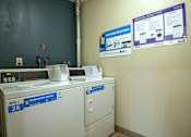 Thumbnail 19 of 26 - a laundry room with two washers and two washing machines