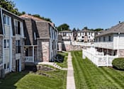 Thumbnail 21 of 33 - A row of apartment buildings with a white picket fence in front.