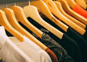 Thumbnail 8 of 8 - Clothes hanging on wooden hangers.