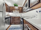 Thumbnail 1 of 35 - A kitchen with a refrigerator, sink, and stove.