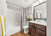 Thumbnail 17 of 35 - A bathroom with a white tub, toilet, and sink.