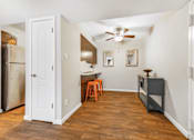 Thumbnail 5 of 35 - A kitchen with a refrigerator, a ceiling fan, and a dining table with chairs.