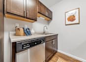 Thumbnail 3 of 35 - A kitchen with brown cabinets and a framed picture of a pumpkin on the wall.