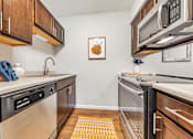 Thumbnail 2 of 35 - A kitchen with a white wall and a picture of a pumpkin hanging on it.