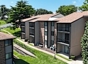 Thumbnail 34 of 35 - Apartment complex with a green lawn in front.