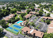 Thumbnail 32 of 35 - A tennis court is surrounded by apartment buildings.