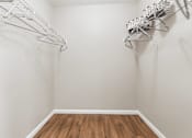 Thumbnail 18 of 35 - A small room with a wooden floor and two wire racks on the wall.