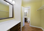 Thumbnail 24 of 35 - A bathroom with a white counter top and a mirror.