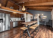 Thumbnail 28 of 35 - A kitchen with a wooden table and stools.